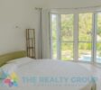 special bedroom with round bed and round window frame overlooking the pool