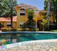 Two main buildings of the B&B, surrounded by tropical greenery, offering both hospitality and residential opportunities in Perla Marina