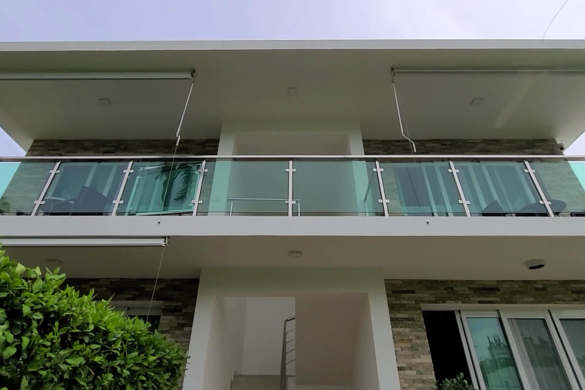 Front view of gated building in Sosúa condos for sale with tropical landscaping
